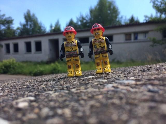 2 Legofiguren auf Stein vor Gebäude