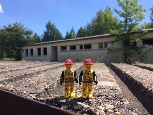 2 Legofiguren auf Stein vor Gebäude
